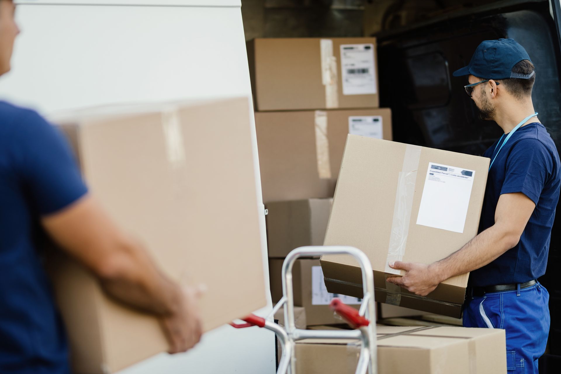 Delivery Workers Loading Packages Into a Van — Dan's Removals In Murwillumbah, NSW