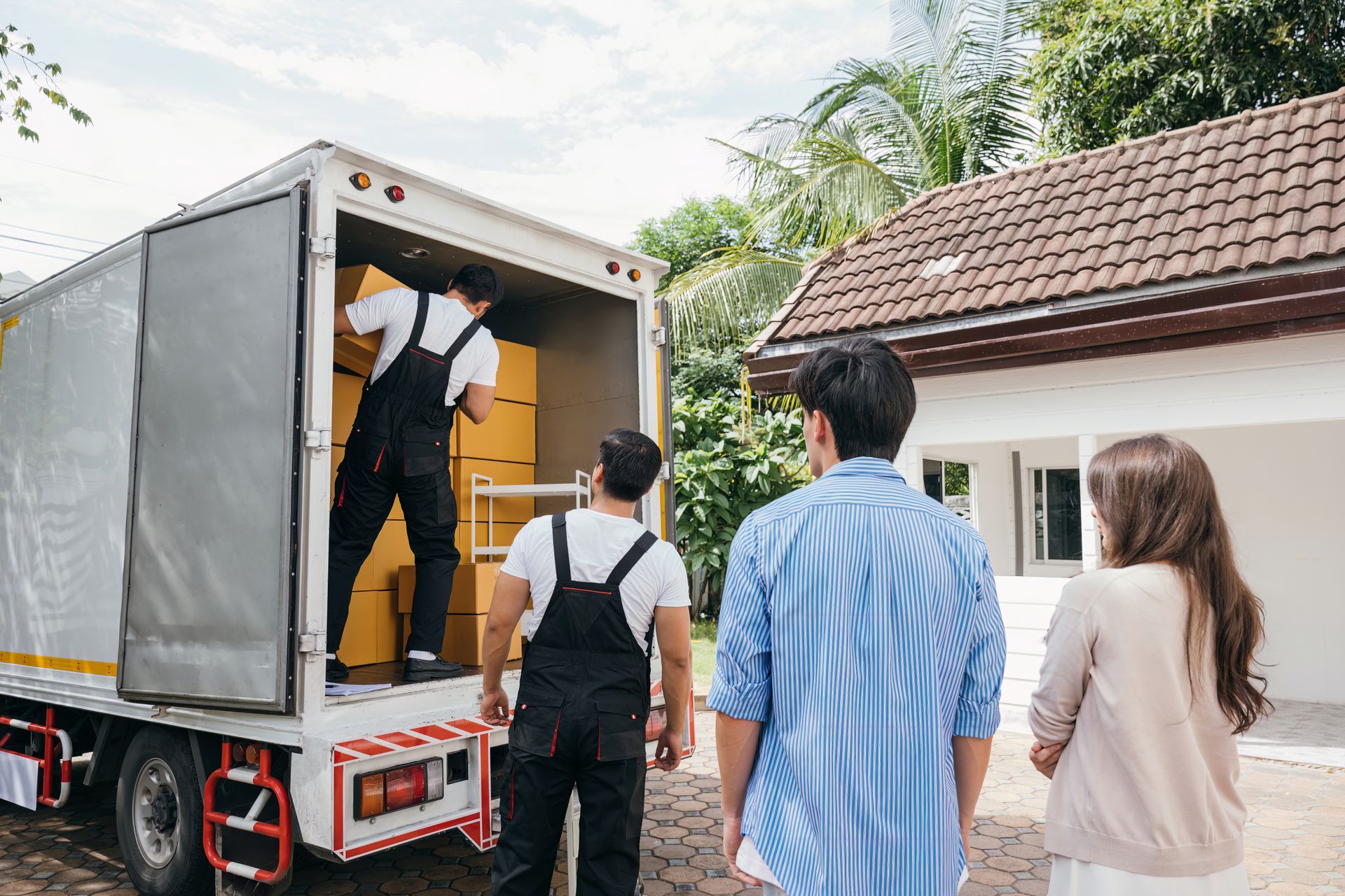 Movers Loading Boxes Into a Truck in Front of A House — Dan's Removals In Brunswick Heads, NSW