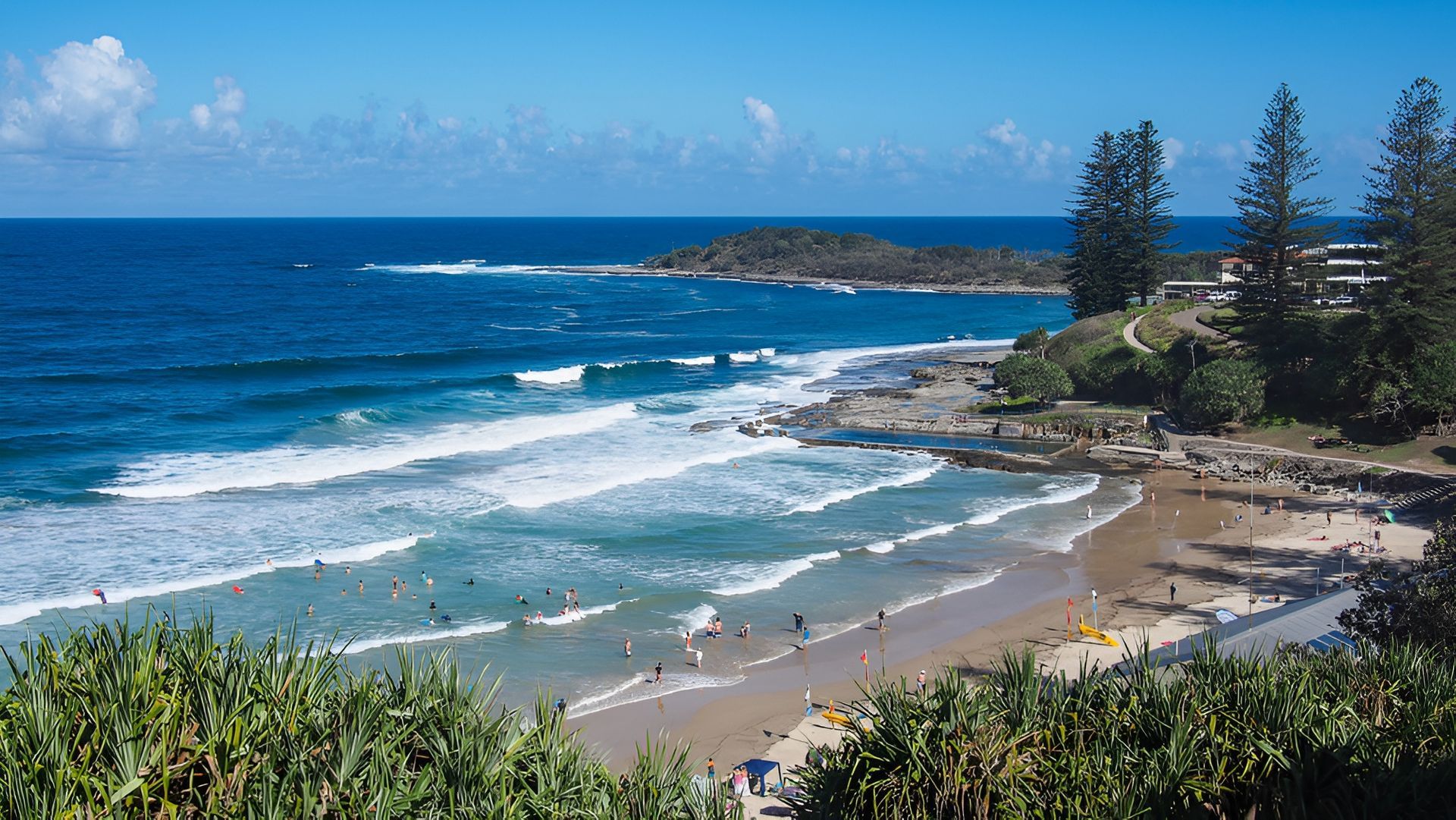 Sunny Beach with Waves, Swimmers, Rocky Headland, and Blue Sky — Dan's Removals In Yamba, NSW