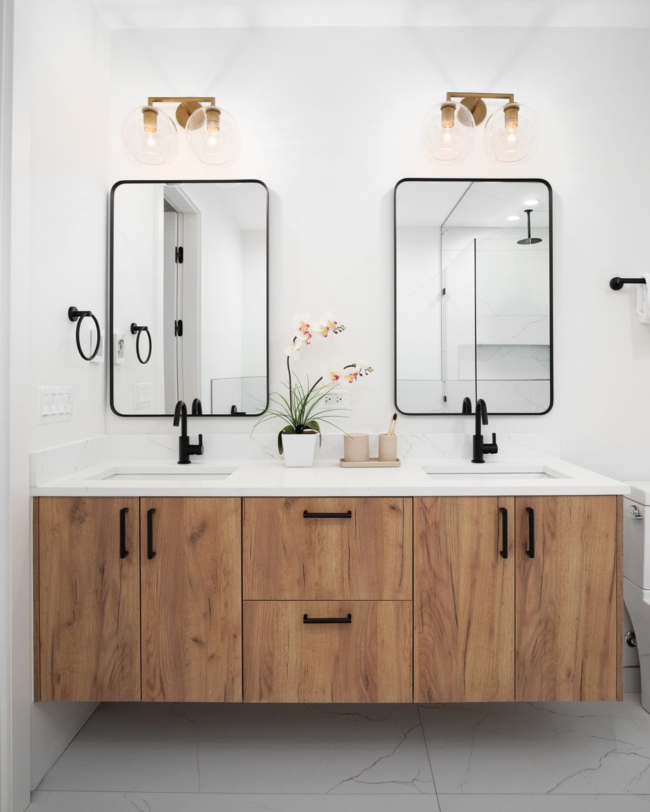 Modern bathroom vanity with double mirrors, black fixtures, white countertop, and wood cabinets