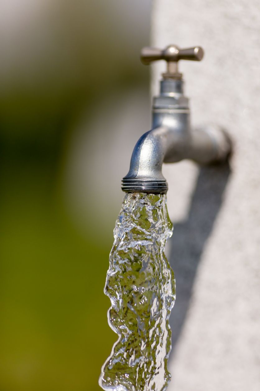 Running water pouring from a silver outdoor faucet