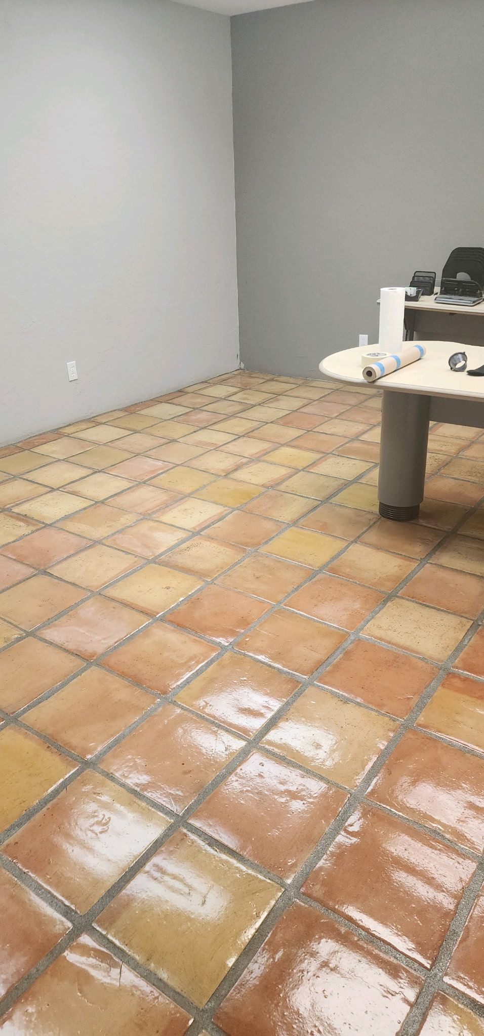 A room with a tiled floor and a desk.