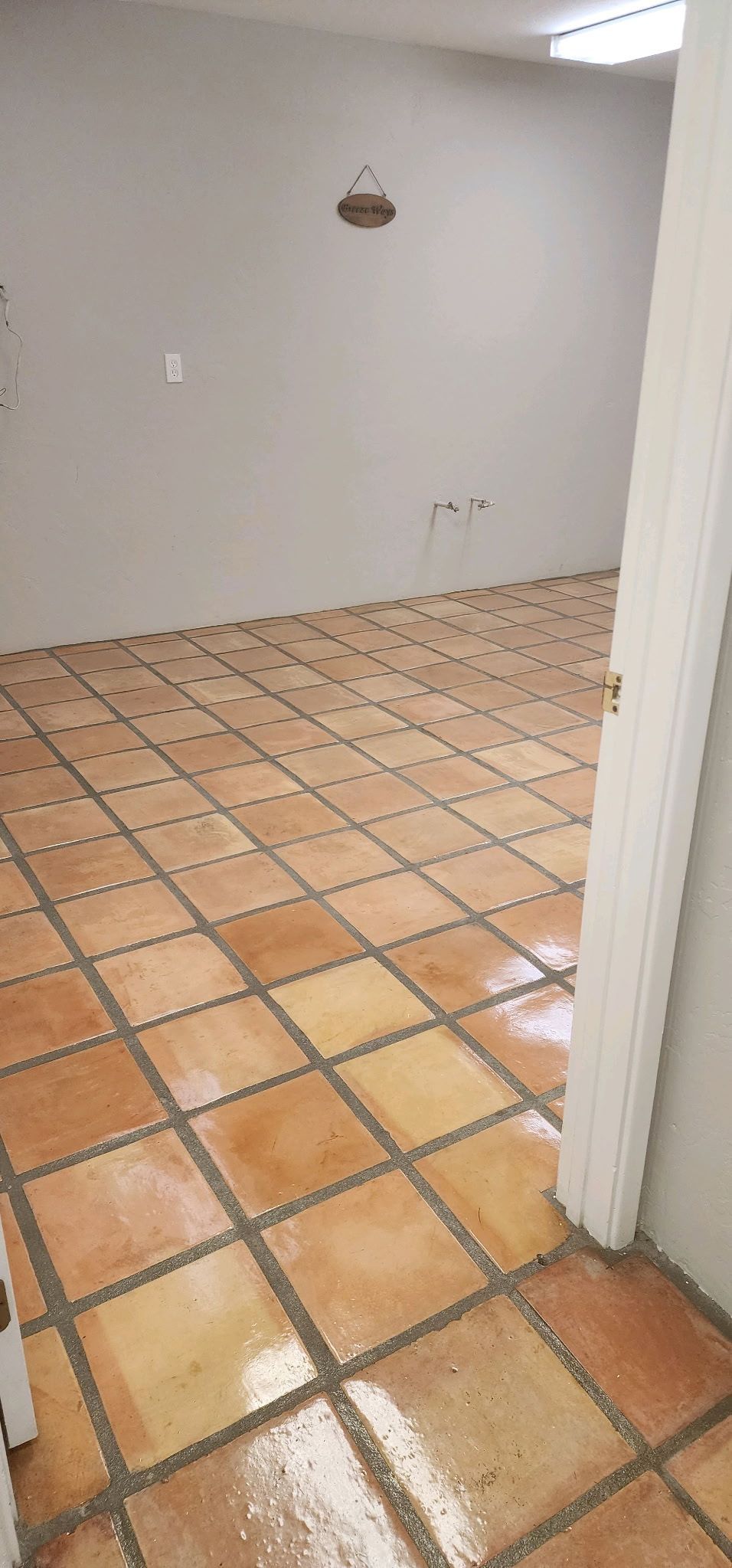 A room with a tiled floor and a white wall.