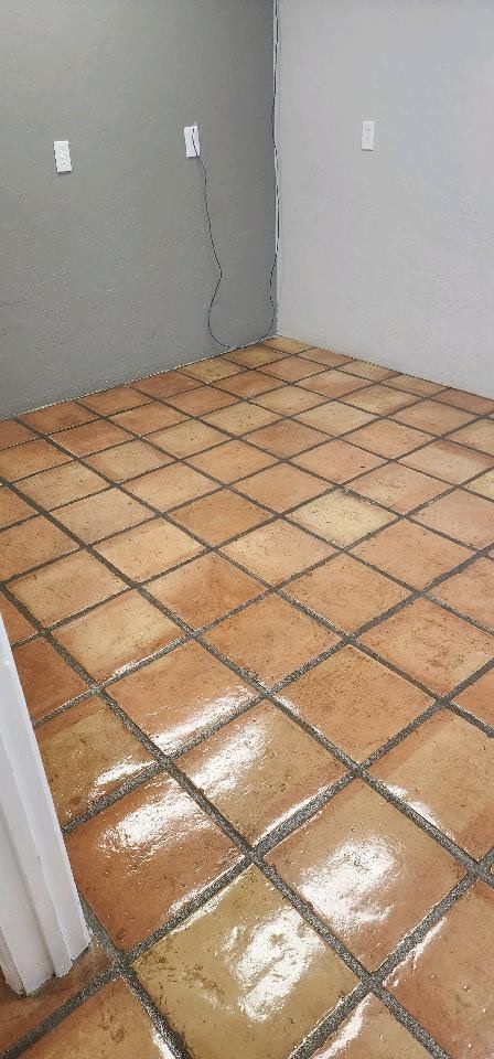 A room with a tiled floor and a gray wall.