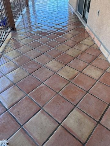 A tiled floor on a balcony with a mop on it.