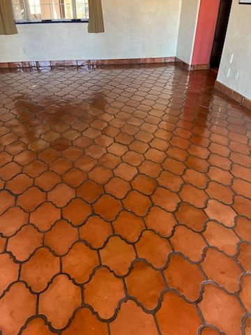 A living room with a tiled floor and a window.