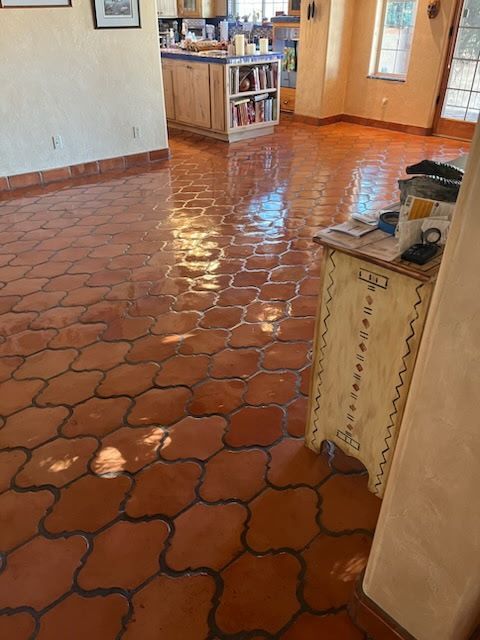 A living room with a red tile floor and a white cabinet.