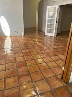 A room with a tiled floor and a door.