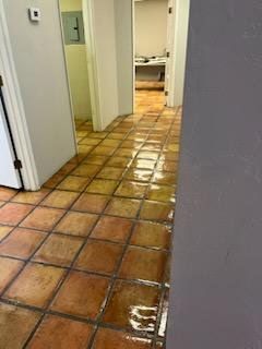 A hallway with tile floors and a purple wall.