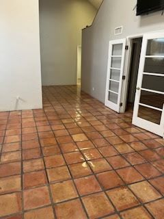 A living room with a tiled floor and white doors.