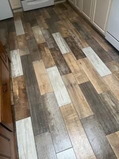 A kitchen with a wooden floor and white cabinets.