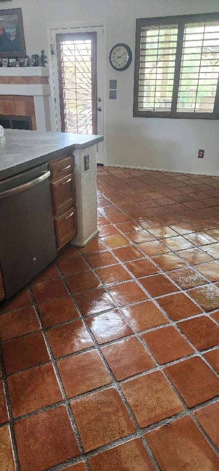 A kitchen with a tile floor and a clock on the wall.