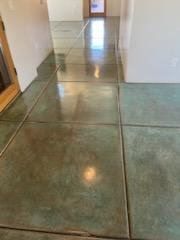 A green tile floor in a hallway in a house.