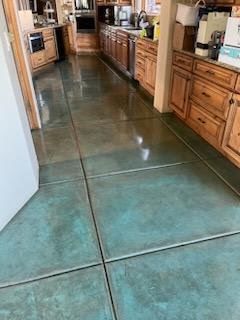 A kitchen with a concrete floor and wooden cabinets.