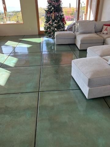 A living room with a couch , ottoman , and a christmas tree.