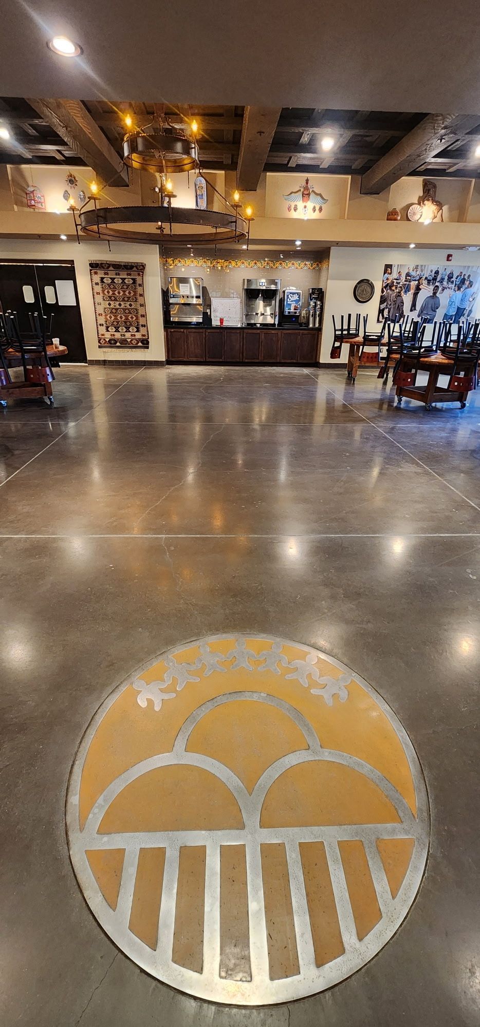 A large room with a basketball logo on the floor.