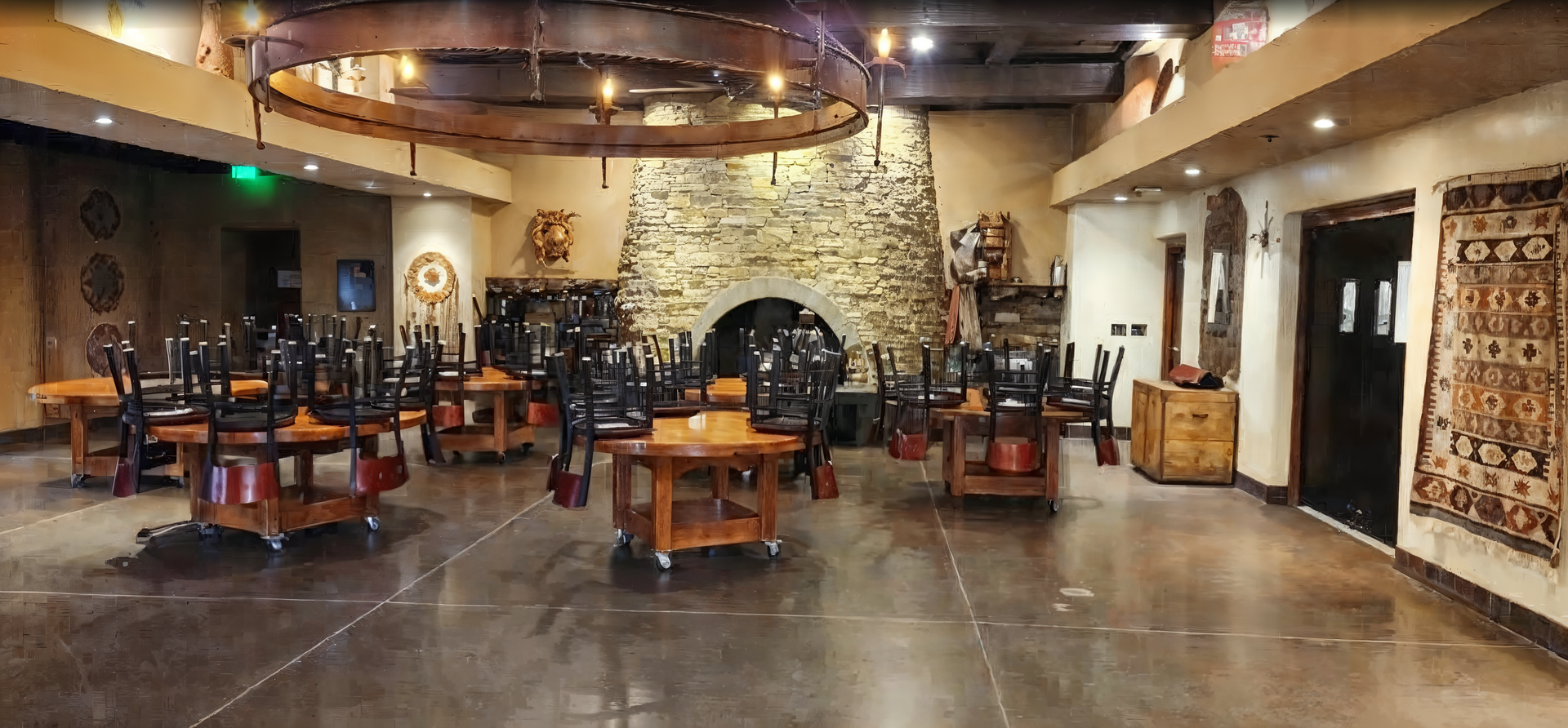 A large room with tables and chairs in it and a fireplace.