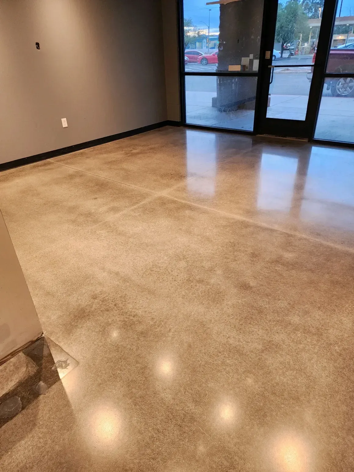 A room with a concrete floor and a glass door.