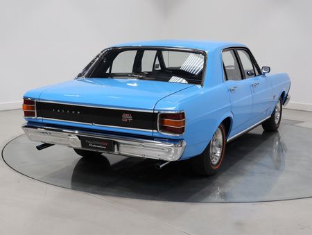 A blue car is parked on a turntable in a showroom