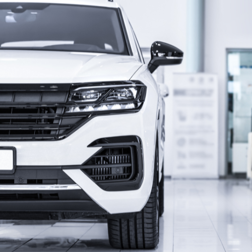 A white suv is parked in a showroom.