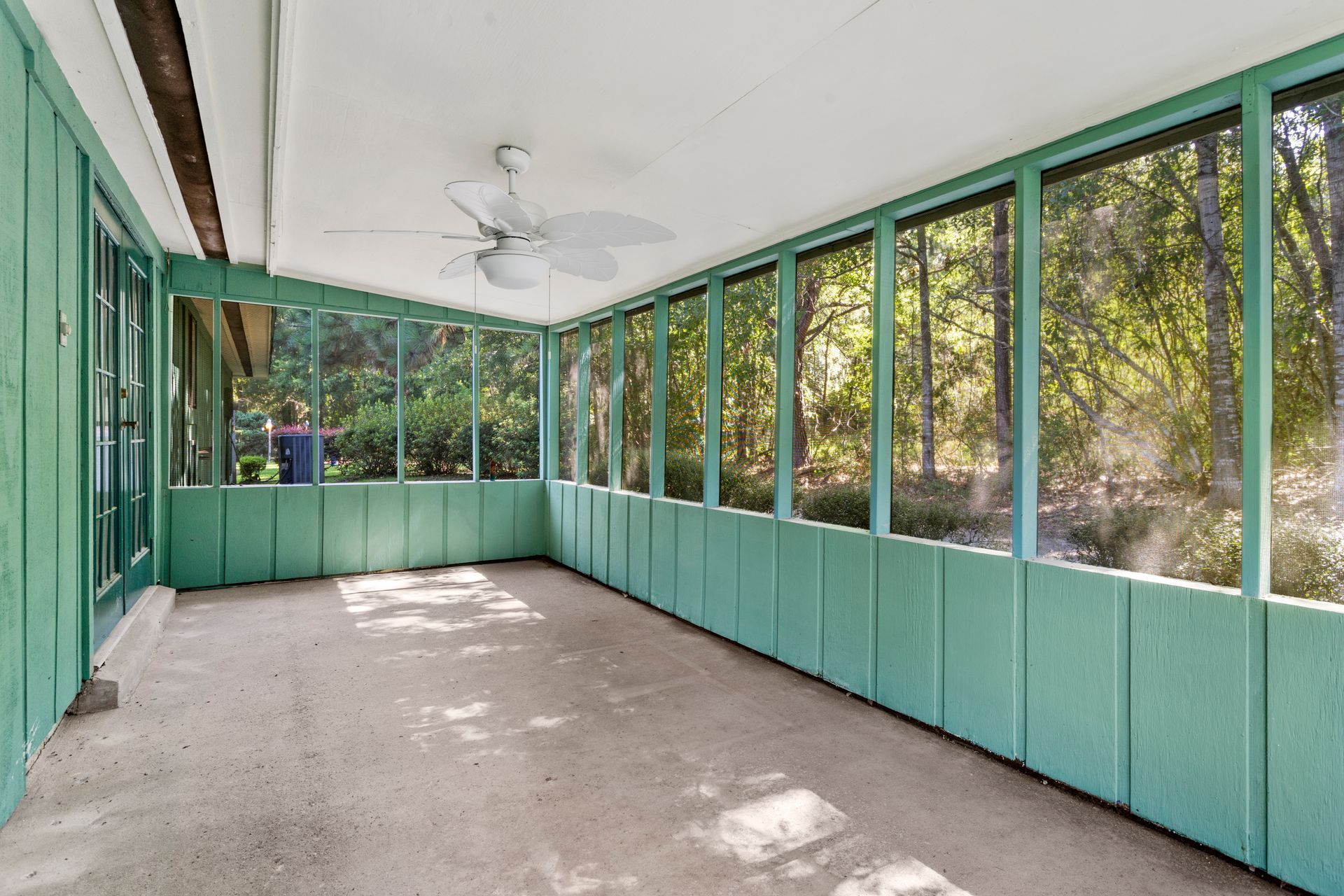 A living room with a couch , chairs , ottoman and a mirror