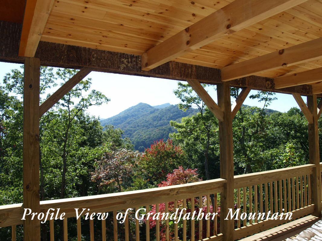Wooden deck overlooking forested mountains under a clear sky, with “Profile View of Grandfather Mountain” text.