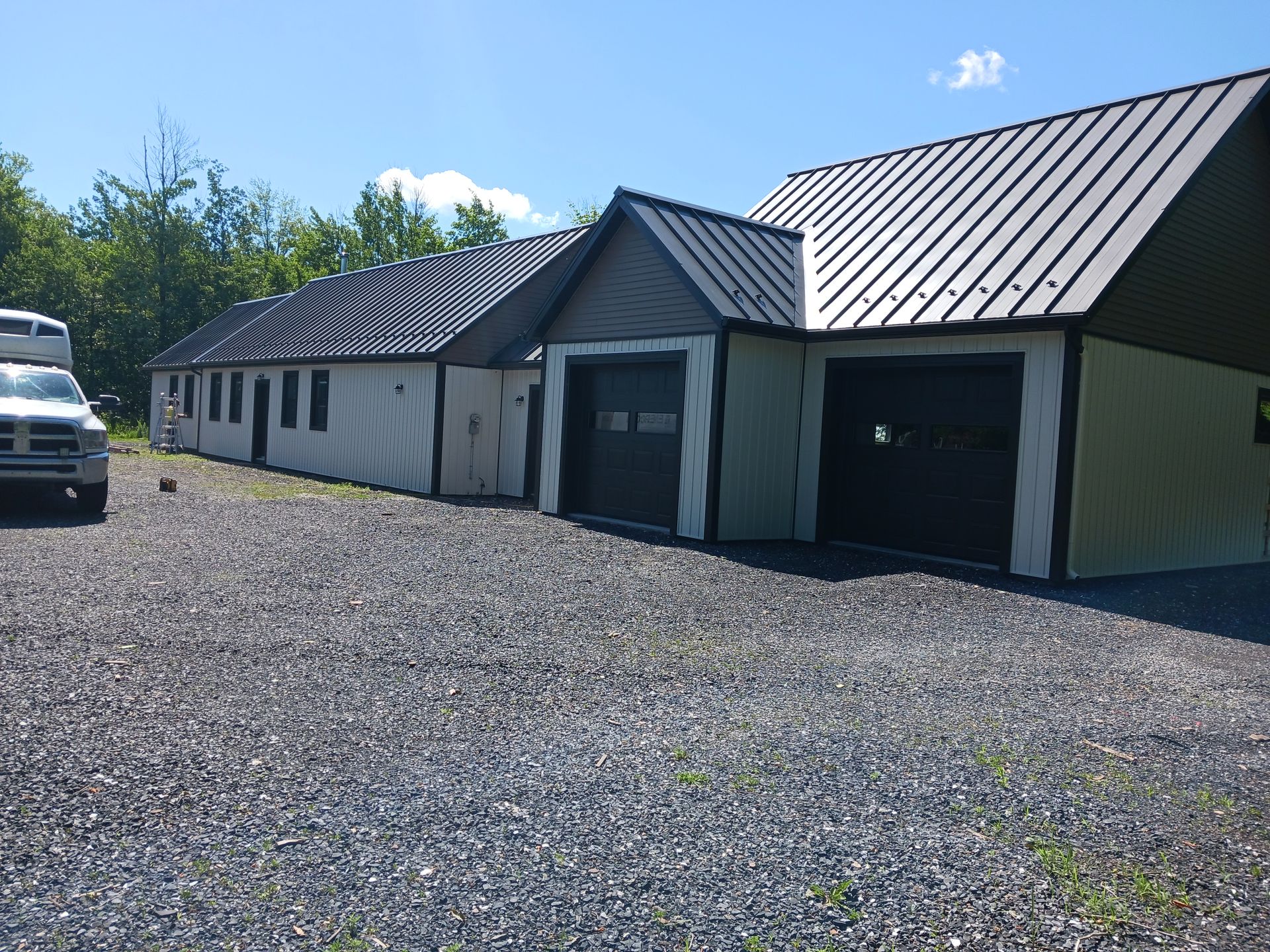 Un camion est garé devant un garage avec un toit en métal.