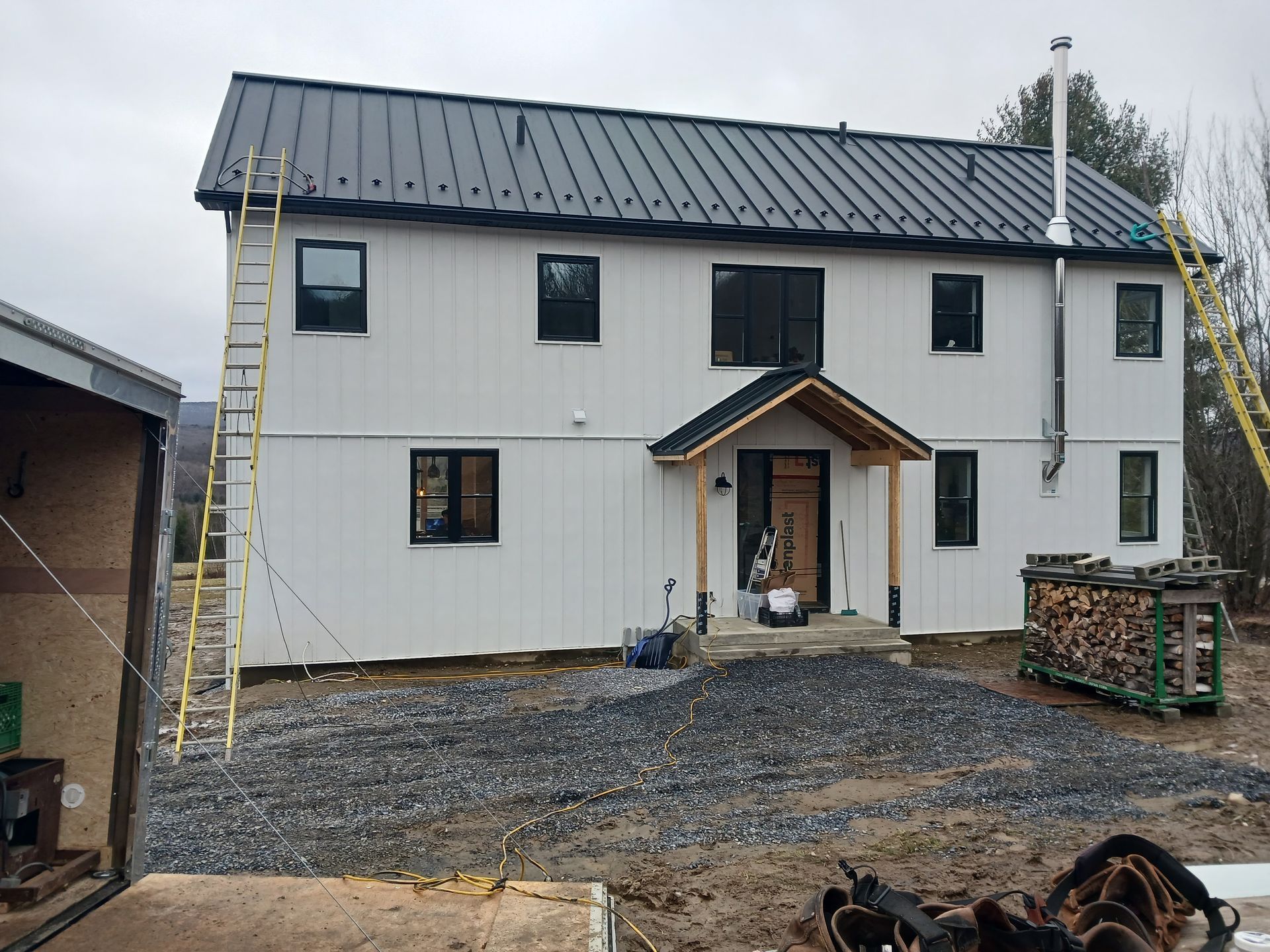 A large white house with a black roof is being built.