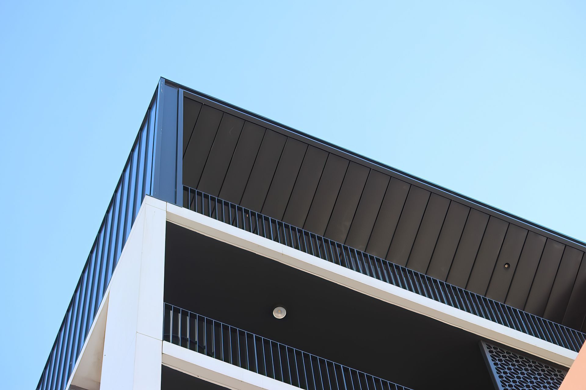 A building with a balcony and a blue sky in the background