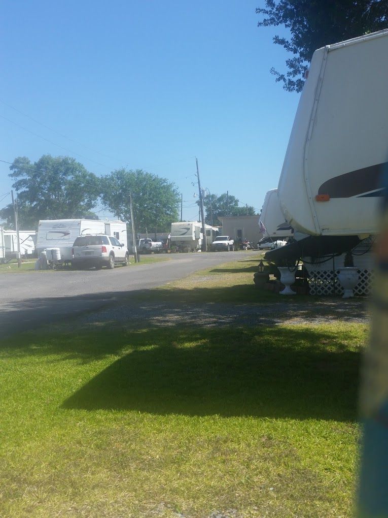 A row of RVs are parked in a parking lot