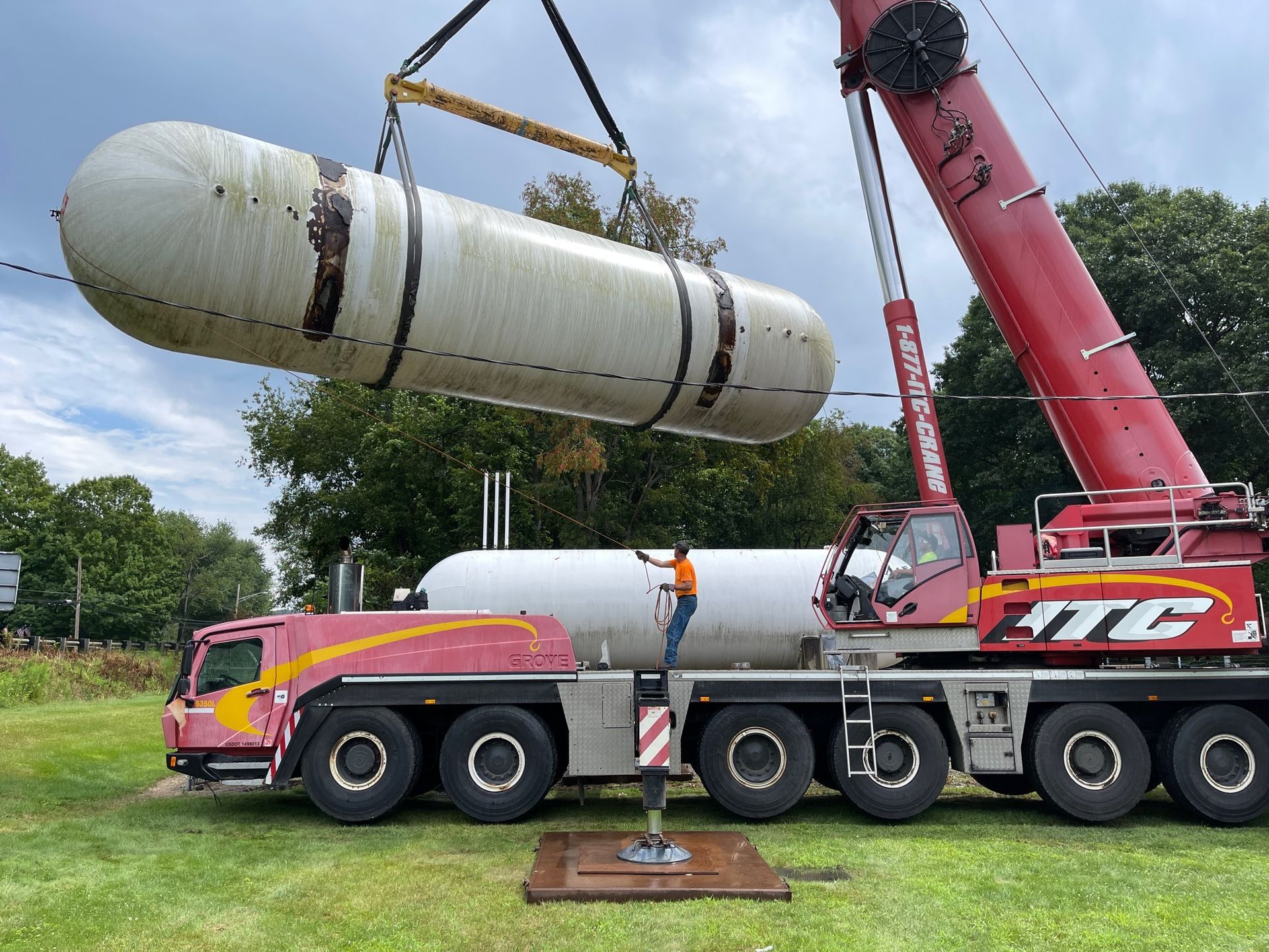 Man inspecting propane tank outdoors, wearing safety glasses and gloves.