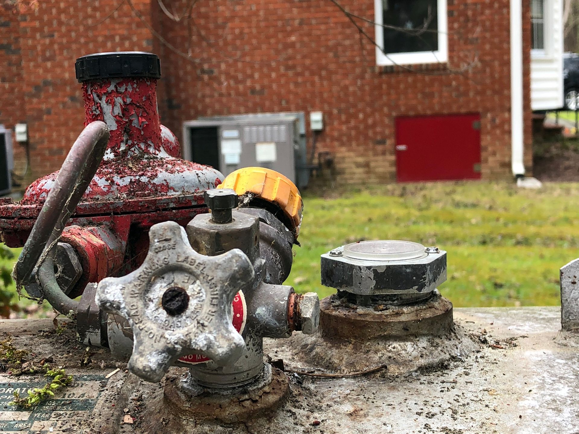 Three pressure gauges are hanging from a pipe on a wall.
