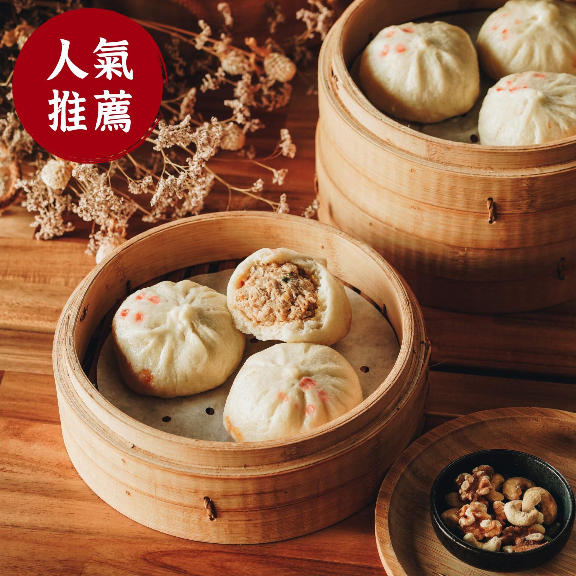 Three bamboo steamers filled with dumplings and nuts on a wooden table.