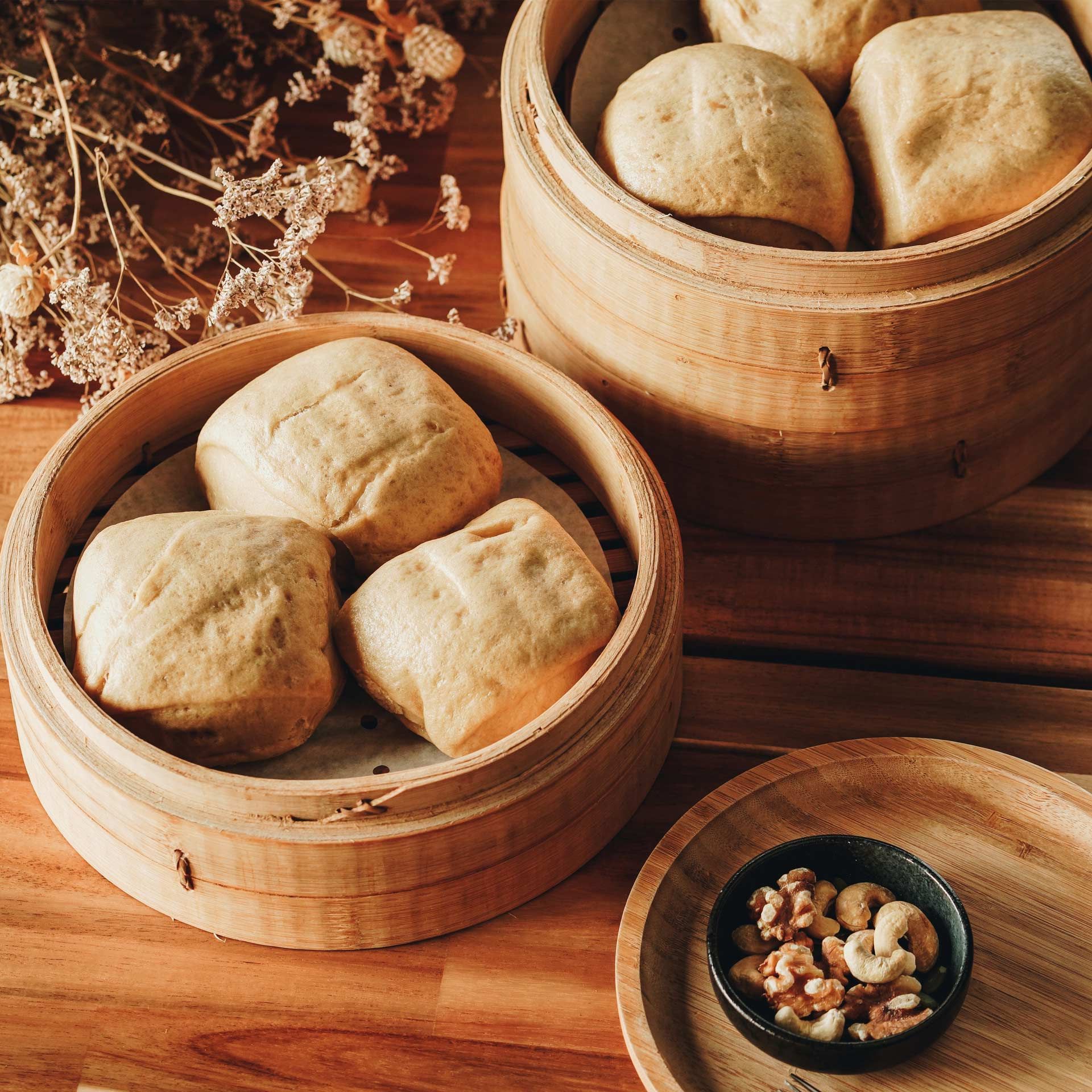 Two wooden steamers filled with bread and nuts