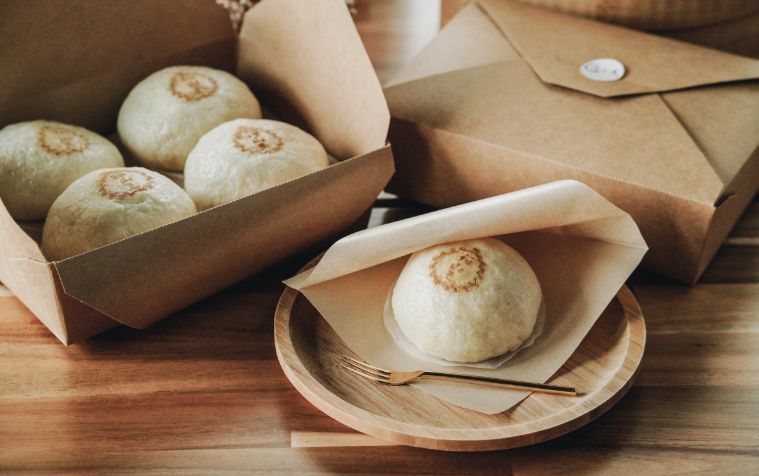 A close up of three dumplings in a bamboo steamer.