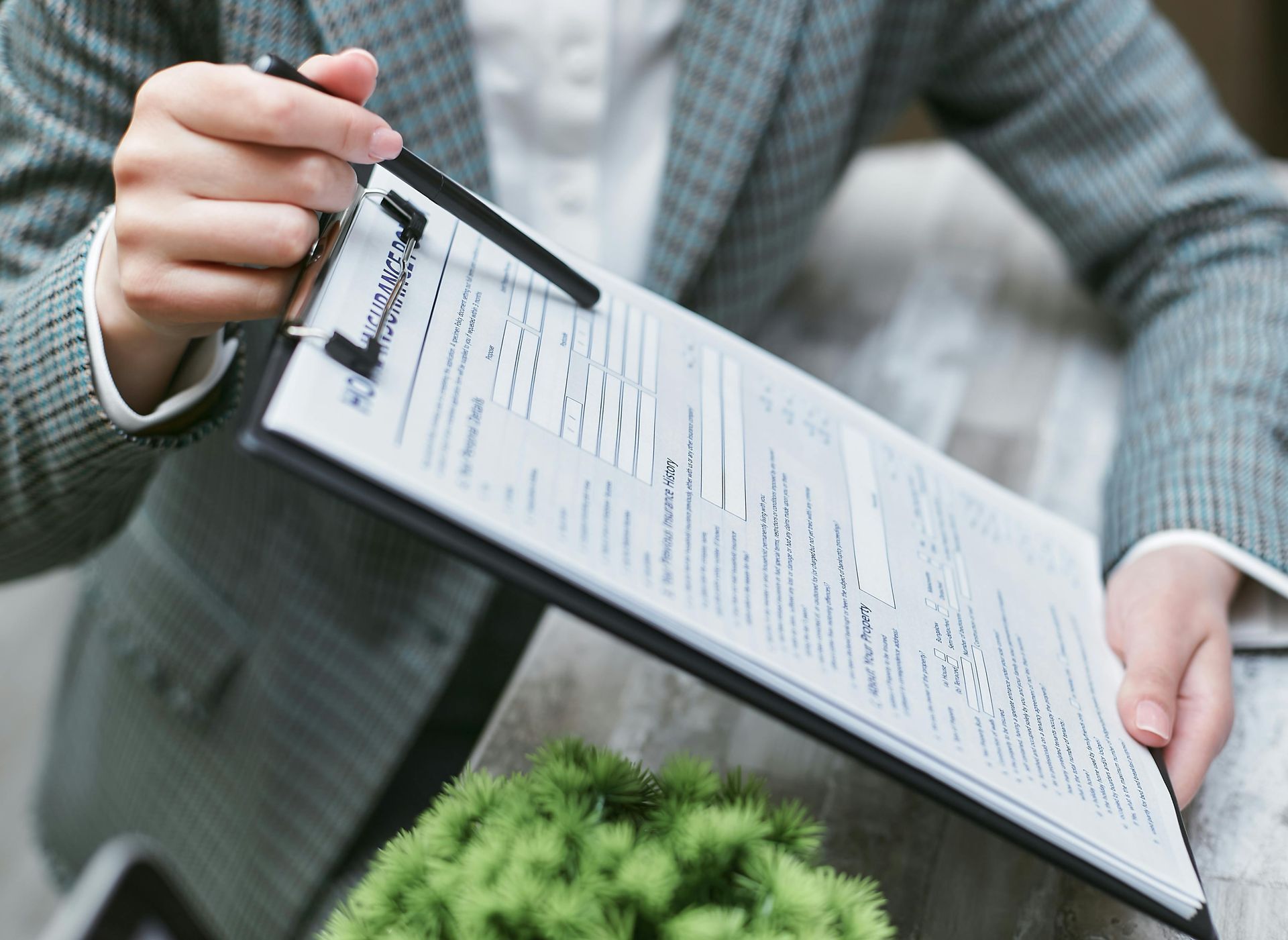 A woman is holding a clipboard with a pen in her hand.