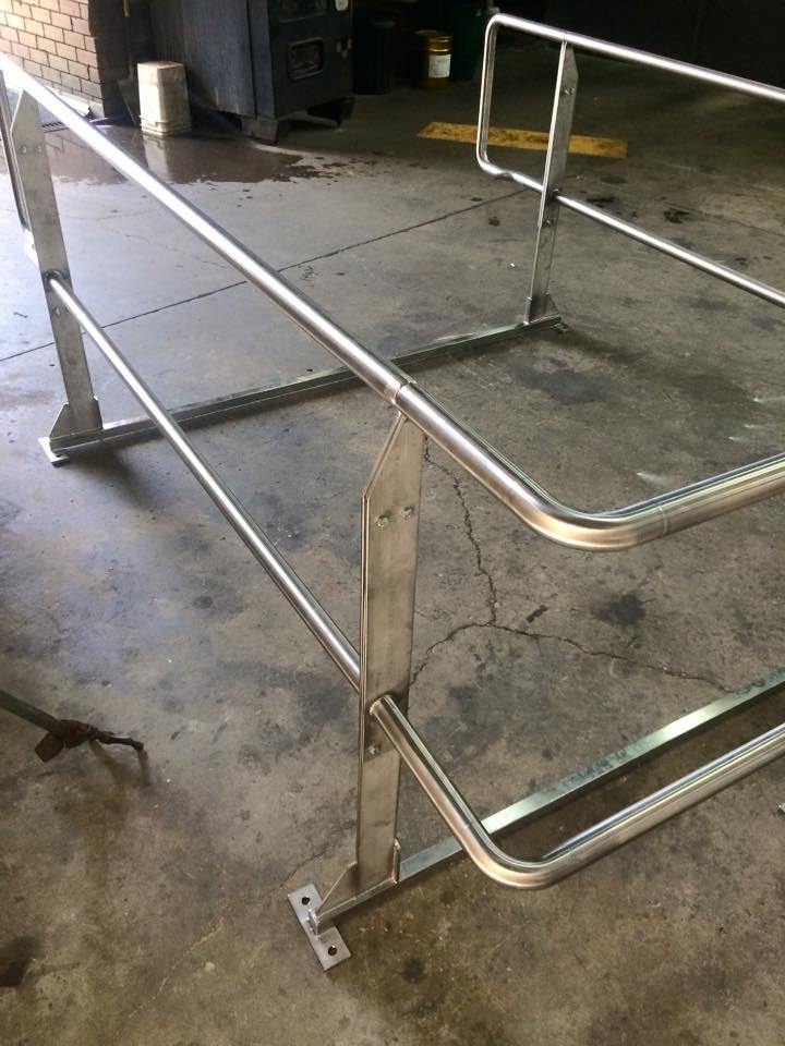 A stainless steel railing is sitting on a concrete floor.