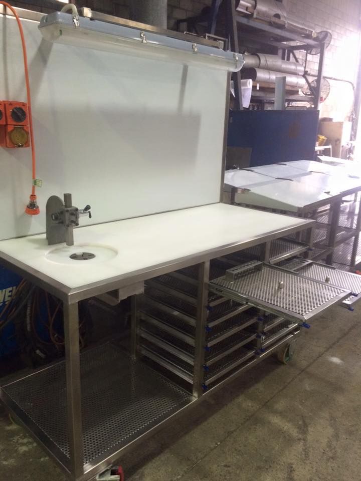 A stainless steel kitchen counter with a sink and shelves.