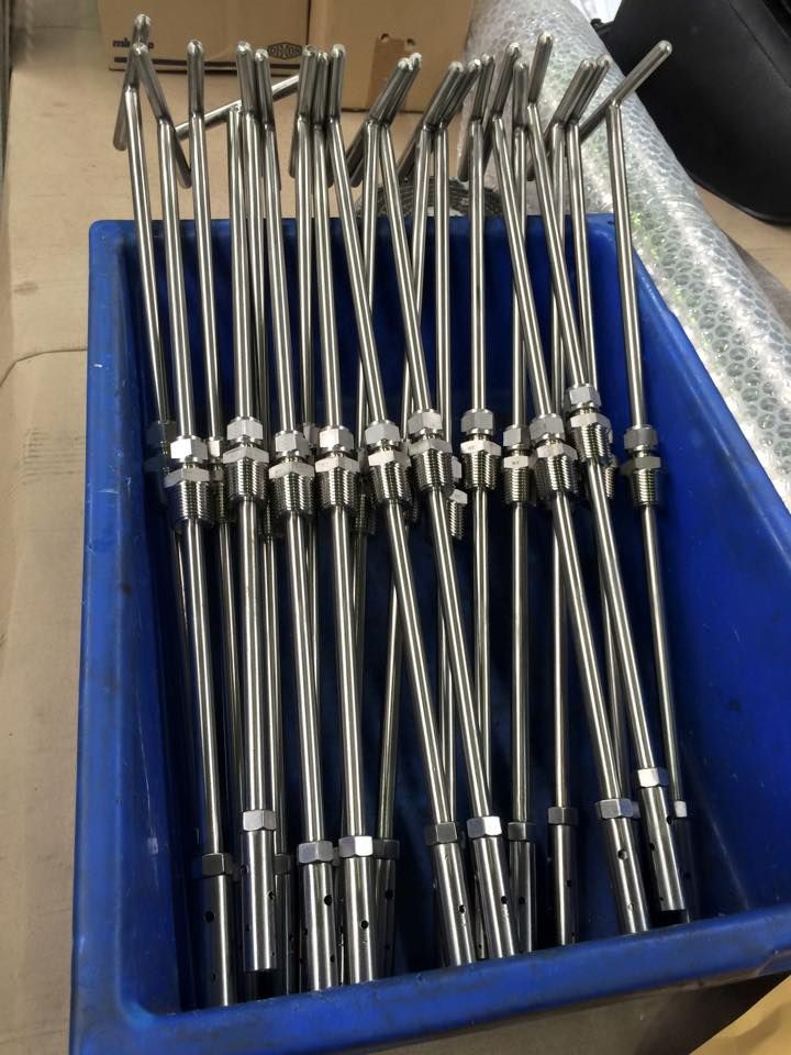 A blue container filled with stainless steel rods on a table.