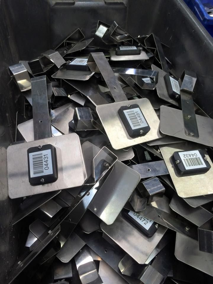 A pile of stainless steel plates with barcodes on them