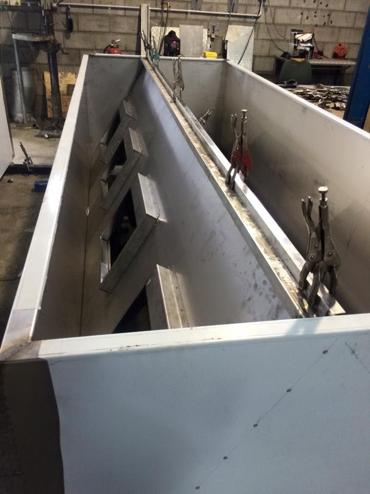 A large stainless steel container is sitting in a factory.