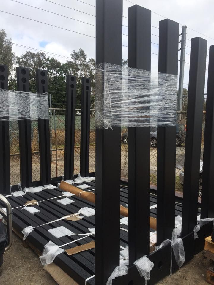 A bunch of black pillars are wrapped in plastic