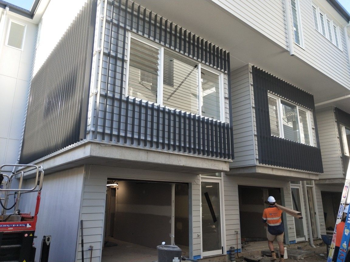 A man is standing in front of a building under construction.