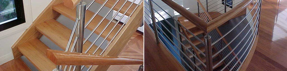 A wooden spiral staircase with a stainless steel railing in a house.