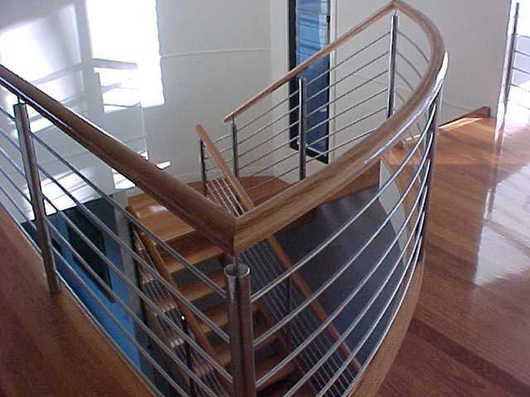 A wooden staircase with a stainless steel railing