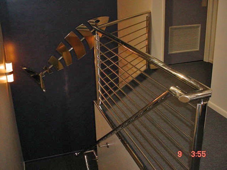 A staircase with a stainless steel railing and the date 9 3:55