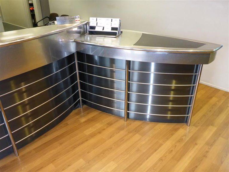 A stainless steel counter with a wooden floor