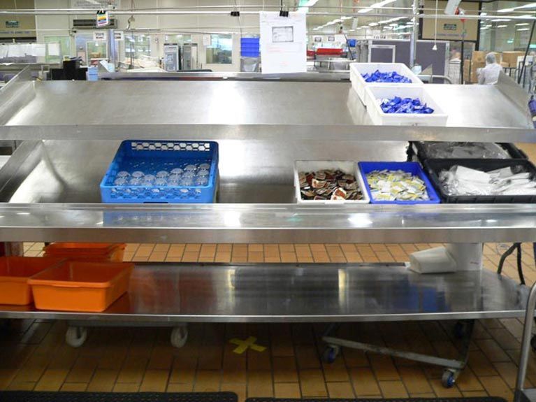 A stainless steel counter with a basket of glasses on it
