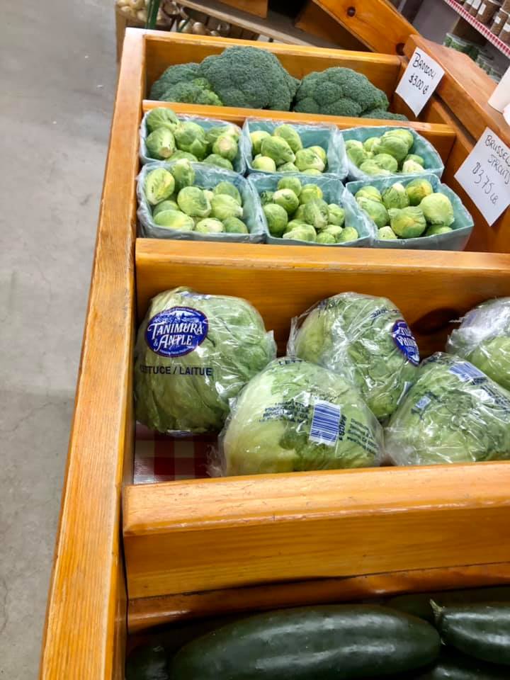 A display of broccoli and brussels sprouts in a grocery store