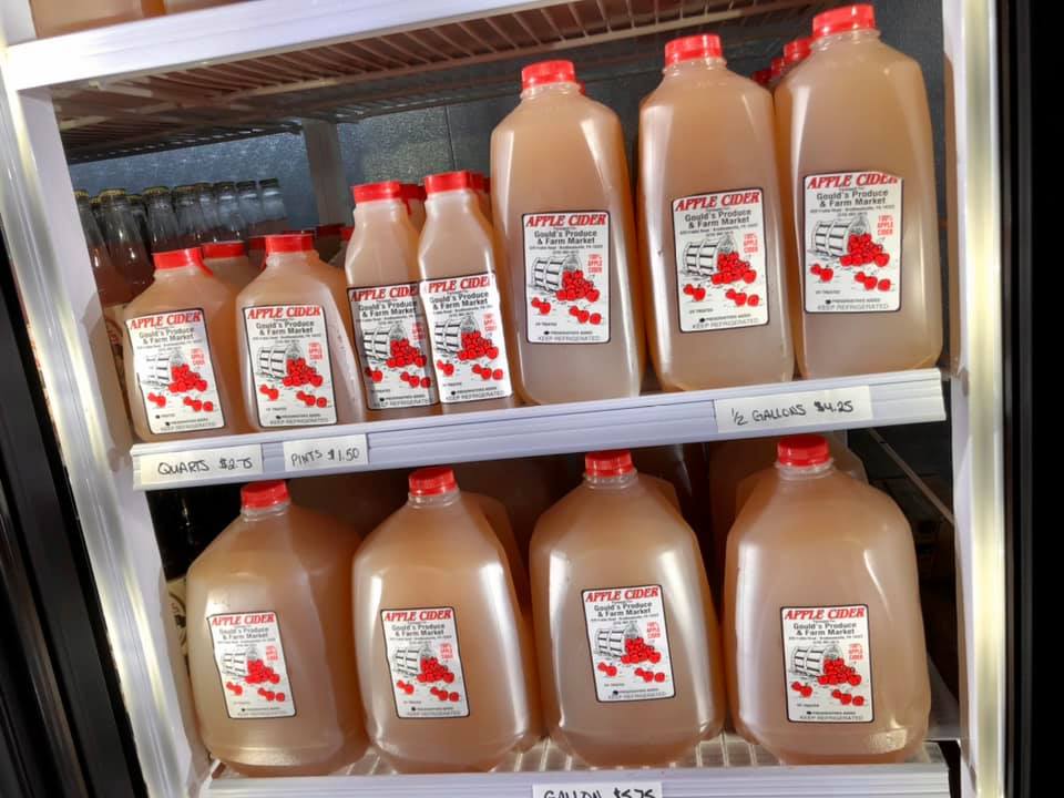 A refrigerator filled with gallons of apple juice
